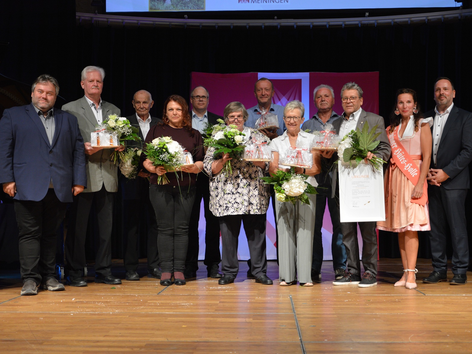 Alle Nominierten der Ehrennadel 2025 zusammen mit Bürgermeister und Hütesholle auf der Bühne. 